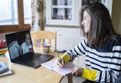 Schülerin am Küchentisch vor dem Laptop