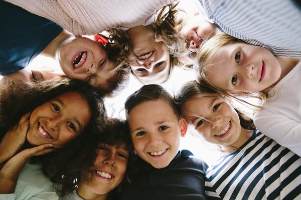 © iStock.com/fotografixx Gesichter von acht Mädchen und Jungen im Kreis